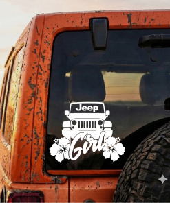 Mud-splattered orange Jeep rear window with a white decal showing a Jeep grille, the word 'Girl', and hibiscus flowers.