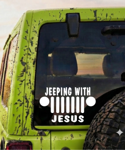 Green muddy jeep seen from the back with a white 'Jeeping with Jesus' logo on the rear window.