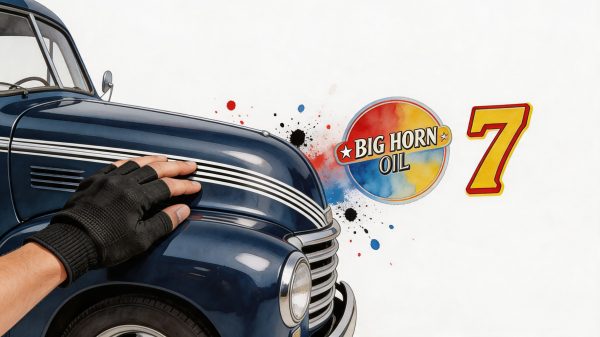 Close-up of a gloved hand resting on the hood of a vintage blue car, with paint-splatter graphic and 'Big Horn Oil' logo in the background.