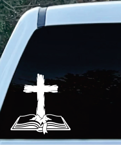 Decorative Christian decal on car window: a white cross rising from an open Bible.