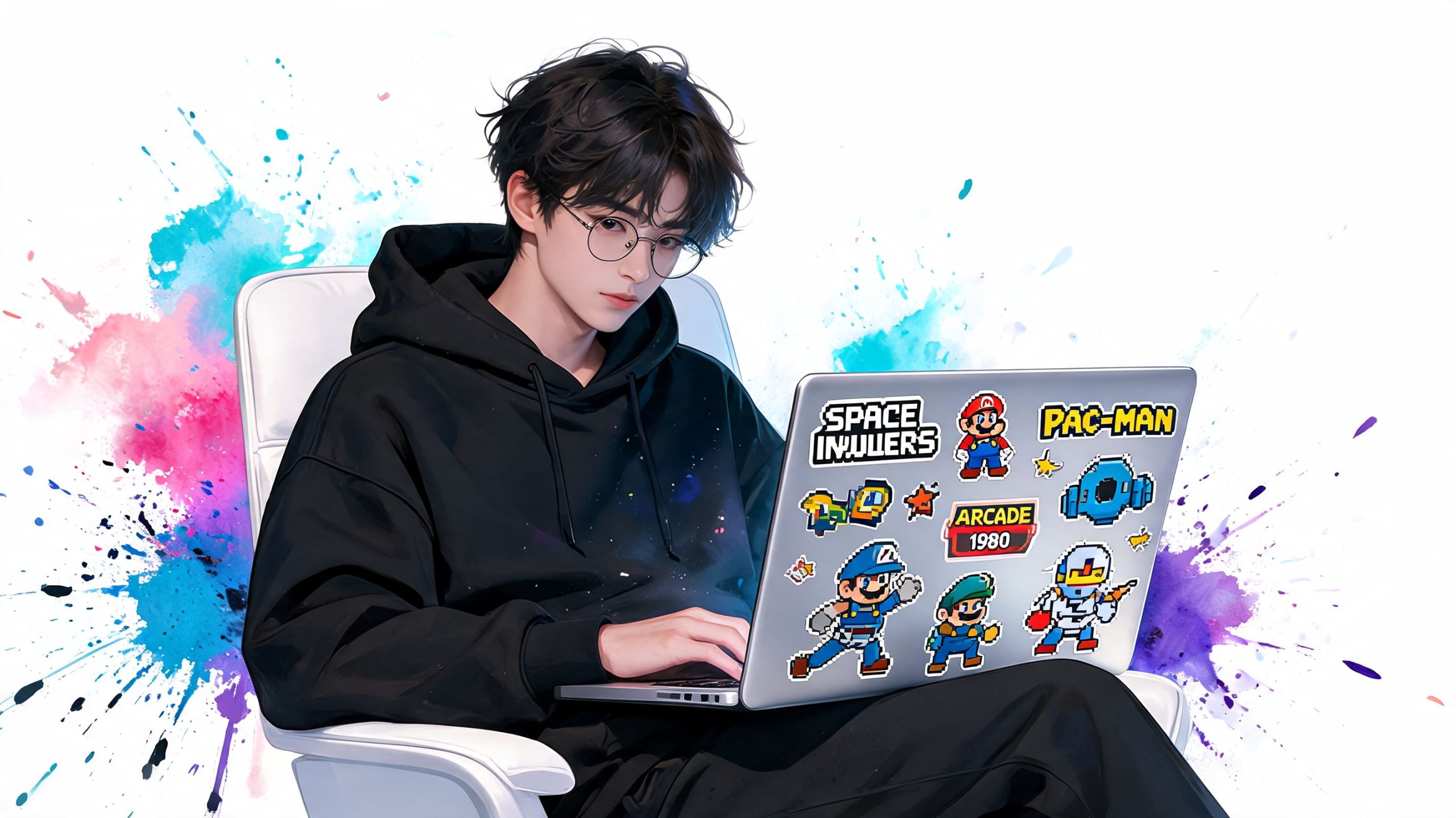A young man with glasses wearing a black hoodie sitting in a chair using a laptop with retro video game stickers.