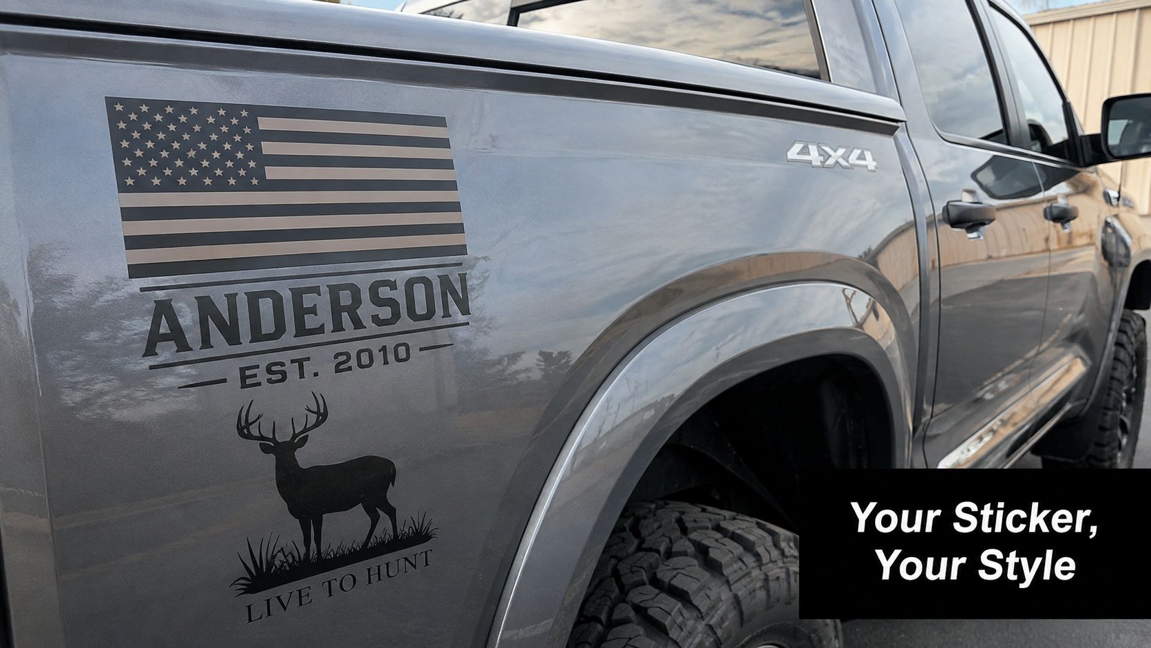 A custom decal featuring an American flag, a deer silhouette, and text on a grey truck.